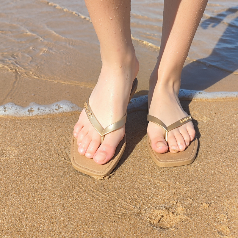 Este chinelo apresenta um design clássico e elegante, perfeito para os dias de verão na praia ou na piscina.  O modelo possui tiras finas na cor dourada, que adicionam um toque de sofisticação e estilo ao calçado. A palmilha é plana e confortável, feita de um material acolchoado que proporciona maciez aos pés, mesmo após longos períodos de uso. A sola é resistente e oferece boa aderência em superfícies molhadas, como areia e áreas próximas à água, garantindo segurança e estabilidade ao caminhar.