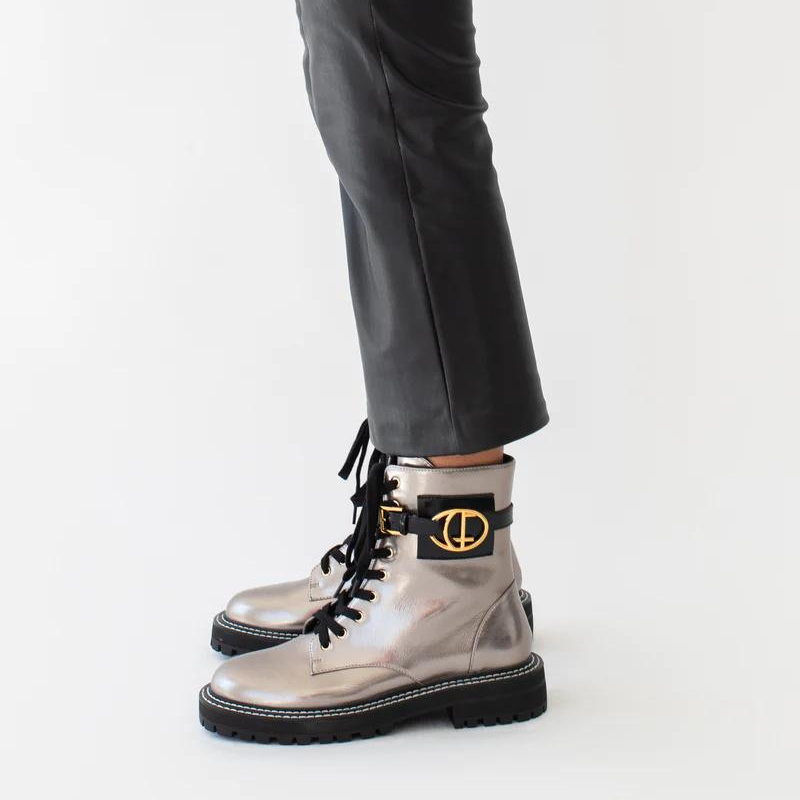 Estas botas estilo militar, são uma escolha elegante para quem procura uma bota que une moda e funcionalidade. A combinação do estilo militar com a cor bronze metalizado torna estas botas exclusivas e estilosas.  São ideais para criar looks ousados e urbanos, enquanto proporcionam conforto e durabilidade.  O toque distintivo destas botas é o acessório com o branding CF. Este detalhe acrescenta personalidade e exclusividade ao design sendo uma característica de destaque.