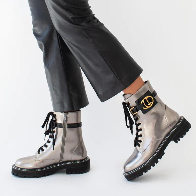 Estas botas estilo militar, são uma escolha elegante para quem procura uma bota que une moda e funcionalidade. A combinação do estilo militar com a cor bronze metalizado torna estas botas exclusivas e estilosas.  São ideais para criar looks ousados e urbanos, enquanto proporcionam conforto e durabilidade.  O toque distintivo destas botas é o acessório com o branding CF. Este detalhe acrescenta personalidade e exclusividade ao design sendo uma característica de destaque.