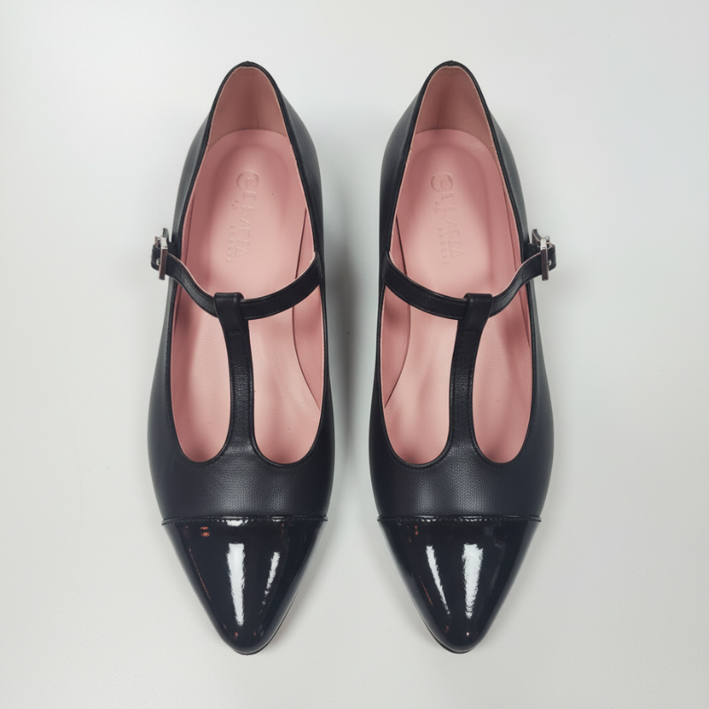 Eleve o seu estilo com estas sofisticadas Mary Jane em pele preta, um clássico intemporal reinventado com elegância contemporânea.

Apresentam uma biqueira pontiaguda em pele envernizada que adiciona um toque de brilho e modernidade, contrastando harmoniosamente com o corpo em pele mate. A icónica tira em T com fivela ajustável em metal dourado não só garante um ajuste perfeito e confortável, como também confere um detalhe distintivo e feminino ao design.