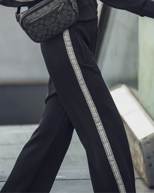 Estas calças de estilo training combinam conforto e modernidade numa peça versátil para o dia a dia.

Confeccionadas em tecido macio e leve, oferecem liberdade de movimento e um ajuste descontraído. O destaque fica por conta das tiras laterais em padrão contrastante, que acrescentam um toque desportivo e contemporâneo ao seu visual.