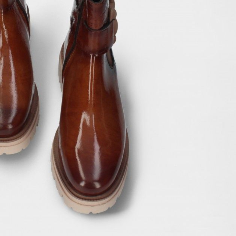 Estas botas Chelsea em verniz macio são uma escolha prática e elegante para enfrentar dias chuvosos.  O design minimalista torna-as versáteis e adequadas para diversas ocasiões, enquanto o verniz proporciona resistência à água, mantendo seus pés secos e confortáveis. São ideais para mulheres que desejam um calçado que combine estilo e funcionalidade.