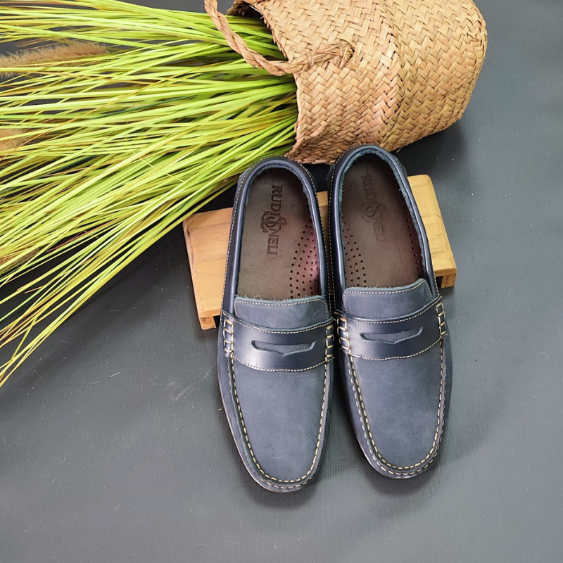 O sapato mocassim é um calçado clássico e versátil, perfeito para diversas ocasiões.  Sem atacadores, desliza facilmente nos pés. Possui um estilo elegante e casual, com uma silhueta de bico arredondado e uma costura em torno da parte superior do calçado. O detalhe do travessão em couro confere um visual sofisticado.  Uma das características marcantes do mocassim é o seu conforto, este modelo é projetado para se ajustar aos pés e oferecer uma sensação de leveza ao caminhar.  Made in Portugal