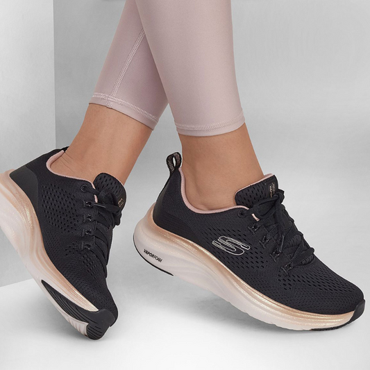 Estas sapatilhas da Skechers, modelo "Vapor Foam - Fresh Trend", combinam design moderno e tecnologia de conforto.

Com um acabamento preto elegante, apresentam detalhes em rosa claro no interior e dourado ao redor da sola, adicionando um toque de delicadeza ao visual esportivo. O tecido respirável proporciona ventilação e ajuste perfeito ao pé, enquanto a entressola em "Vapor Foam" oferece uma absorção de impacto superior, garantindo conforto durante todo o dia.&nbsp;