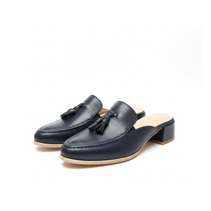 Reinvente o seu estilo com esta mule loafer em couro azul-marinho, a peça perfeita para quem procura praticidade sem abdicar da elegância.

Os berloques em couro são o elemento distintivo deste modelo, conferindo personalidade e um ar contemporâneo que se destaca. O tom azul-marinho profundo é uma alternativa sofisticada ao preto tradicional, trazendo cor ao seu guarda-roupa mantendo a versatilidade que procura. 