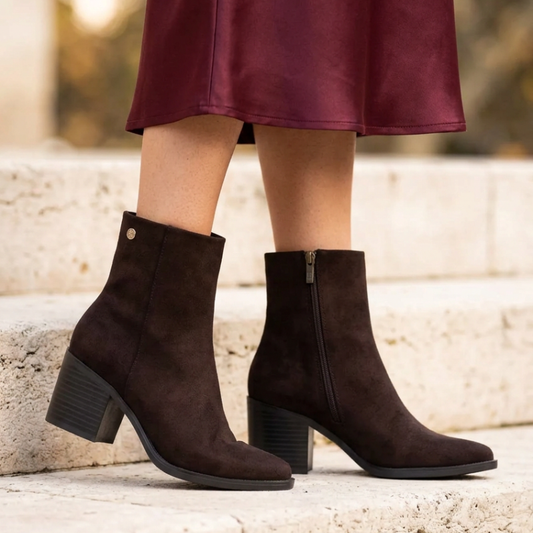 Este botim combina linhas elegantes com um estilo versátil, ideal para complementar os looks de outono e inverno.

O acabamento aveludado e a biqueira ligeiramente afunilada conferem-lhe um toque sofisticado, enquanto o salto médio e largo, em contraste com a parte superior, acrescenta personalidade ao modelo. O cano de linhas simples é rematado por um pequeno detalhe metálico na lateral exterior, e o fecho de correr no lado interior facilita o calçar.