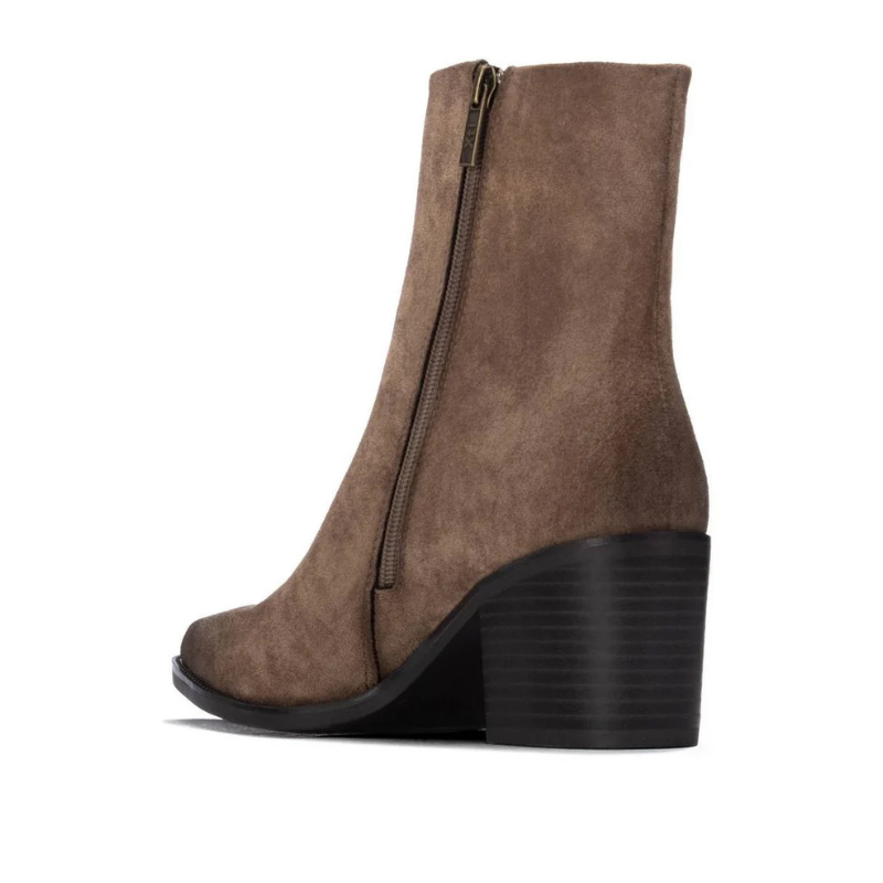 Este botim combina linhas elegantes com um estilo versátil, ideal para complementar os looks de outono e inverno.

O acabamento aveludado e a biqueira ligeiramente afunilada conferem-lhe um toque sofisticado, enquanto o salto médio e largo, em contraste com a parte superior, acrescenta personalidade ao modelo. O cano de linhas simples é rematado por um pequeno detalhe metálico na lateral exterior, e o fecho de correr no lado interior facilita o calçar.