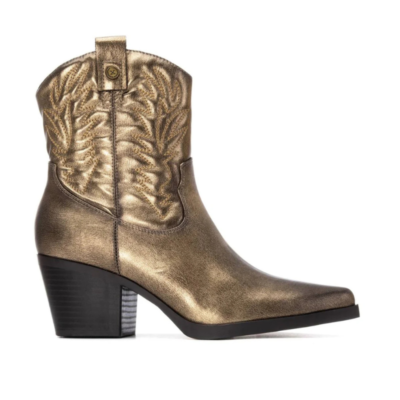 Este botim de inspiração western combina autenticidade e elegância num design marcante.

Com acabamento metalizado em tom dourado, destaca-se pela textura brilhante e pelos bordados decorativos no cano, que reforçam seu estilo texano clássico. O modelo possui forma bicuda e salto bloco médio, garantindo estabilidade e conforto ao caminhar, além de trazer um toque sofisticado ao visual.