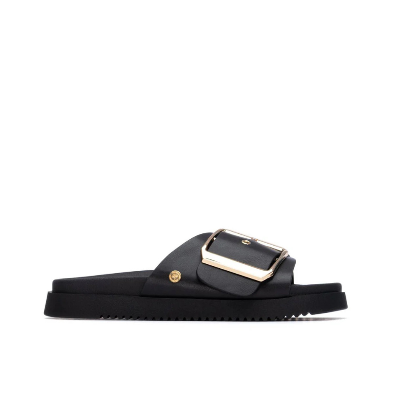 Minimalista e com um impacto visual inegável, este chinelo plano em preto é uma peça que redefine o conceito de casual chic.

A tira larga e estruturada, decorada com uma fivela oversized em dourado, transforma um modelo de inspiração clássica numa declaração de estilo contemporânea. A sola plataforma em borracha preta, ligeiramente elevada, confere conforto e estabilidade ao longo do dia, enquanto a palmilha macia acompanha o pé com suavidade.