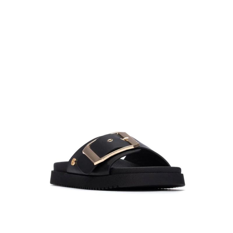 Minimalista e com um impacto visual inegável, este chinelo plano em preto é uma peça que redefine o conceito de casual chic.

A tira larga e estruturada, decorada com uma fivela oversized em dourado, transforma um modelo de inspiração clássica numa declaração de estilo contemporânea. A sola plataforma em borracha preta, ligeiramente elevada, confere conforto e estabilidade ao longo do dia, enquanto a palmilha macia acompanha o pé com suavidade.
